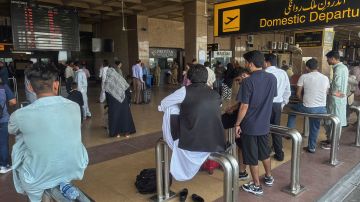 Pasajeros varados esperan en la zona de llegadas del aeropuerto de Jinnah, después de que las autoridades cerraran el aeropuerto debido al ataque con drones de India a Pakistán.