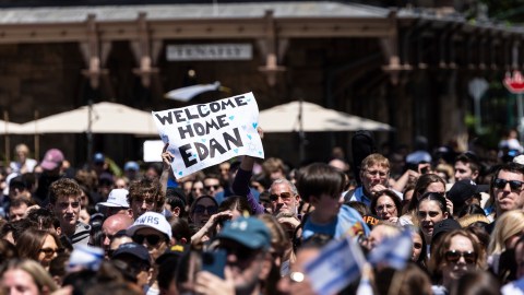 Personas reunidas celebran la liberación del rehén estadounidense Edan Alexander, de manos de Hamás.