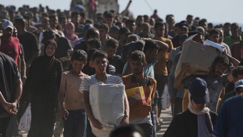 Palestinos llevan cajas con alimentos y paquetes de ayuda humanitaria entregados por la Fundación Humanitaria de Gaza, una organización respaldada por Estados Unidos y aprobada por Israel.