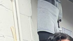 El maestro de costura Hugo Herrera (centro) acompañado de varios de sus pupilos en el taller de costura.