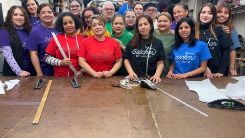 El maestro de costura Hugo Herrera (centro) acompañado de varios de sus pupilos en el taller de costura.