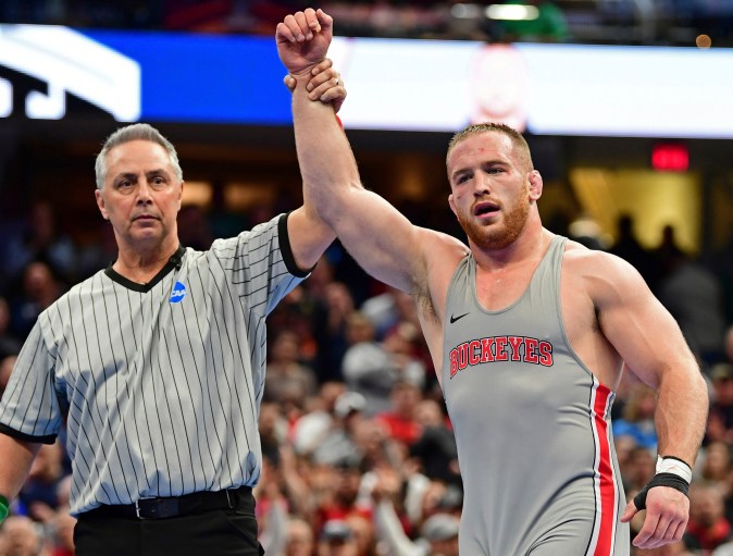 Kyle Snyder, de Ohio State (derecha), levanta el brazo tras derrotar a Adam Coon, de Michigan, durante la final de la categoría de 137 kg del Campeonato de Lucha Libre de la División I de la NCAA, el sábado 17 de marzo de 2018 en Cleveland. (Foto AP/David Dermer)