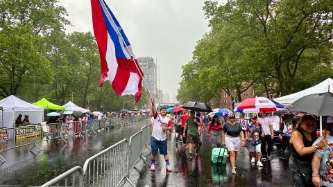 A pesar de la pertinaz lluvia la bandera puertorriqueña flameó por todo lo alto en el festival de la Calle 116 que reunió a miles de visitantes. /Jenny Saavedra