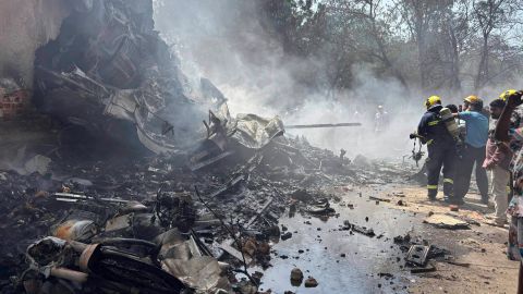 Bomberos rociaron con agua los restos humeantes del avión, que habría estado completamente cargado de combustible poco después del despegue.