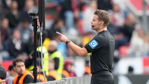 Mientras un árbitro verifica una jugada en la pantalla del VAR, las imágenes que observa serán proyectadas en el estadio para que el público comprenda cuál es la revisión.