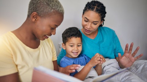 Reading,,Lgbt,Family,And,Child,With,A,Book,In,Bed