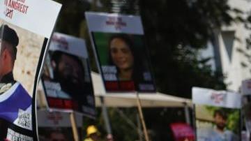 Imágenes de rehenes israelíes retenidos por Hamás en Gaza, colocados sobre una valla de alambre de púas durante una manifestación de familiares y simpatizantes que exigían un alto el fuego y un acuerdo para la liberación de los rehenes, frente al cuartel general militar de Kirya en Tel Aviv, Israel, el 2 de agosto de 2025.