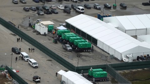 Agentes del orden caminan cerca de camionetas mientras avanzan las obras de un nuevo centro de detención de migrantes, denominado "Alligator Alcatraz", en el Centro de Entrenamiento y Transición Dade-Collier en los Everglades de Florida, el viernes 4 de julio de 2025, en Ochopee, Florida.