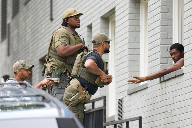 Agentes armados se preparan para esposar a un hombre desde un complejo de apartamentos, el martes 19 de agosto de 2025, en el barrio de Petworth, al noroeste de Washington.