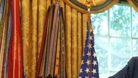 El presidente Donald Trump sostiene gráficos mientras habla sobre la economía en la Oficina Oval de la Casa Blanca.