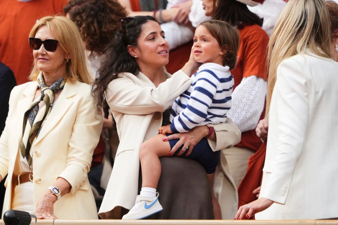 La esposa de Rafa Nadal, María Francisca Perelló, sostiene a su hijo Rafael Junior durante una ceremonia de despedida en la cancha central Philippe-Chatrier del estadio Roland-Garros de París, el domingo 25 de mayo de 2025. (Foto AP/Lindsey Wasson)