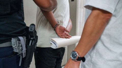 Un hombre sostiene sus documentos de inmigración después de ser detenido por agentes de ICE en una corte de inmigración en NY..