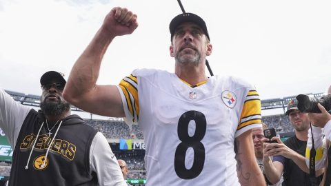 Aaron Rodgers festeja con los fanáticos tras vencer a los Jets.