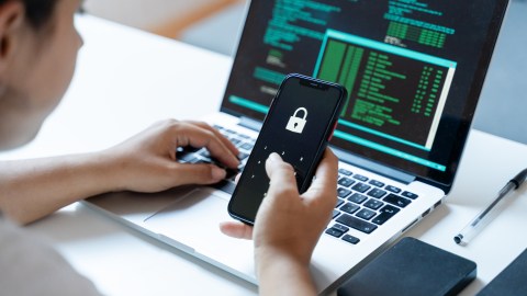 Cyber security concept. Young woman using mobile phone with padlock on screen.
