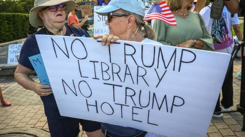 Una persona muestra un cartel durante una protesta contra la construcción de la biblioteca presidencial de Donald Trump este lunes, en Miami (EE.UU.).