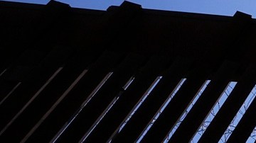 Agentes de la Patrulla Fronteriza y miembros del ejército se encuentran dentro de una puerta en uno de los dos muros fronterizos que separan México de EE.UU.