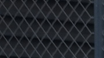 Agentes del Departamento de Seguridad Nacional (DHS) custodian la entrada al edificio federal adyacente al Centro Metropolitano de Detención mientras manifestantes se mantienen al margen en Los Ángeles, el martes 15 de julio de 2025.