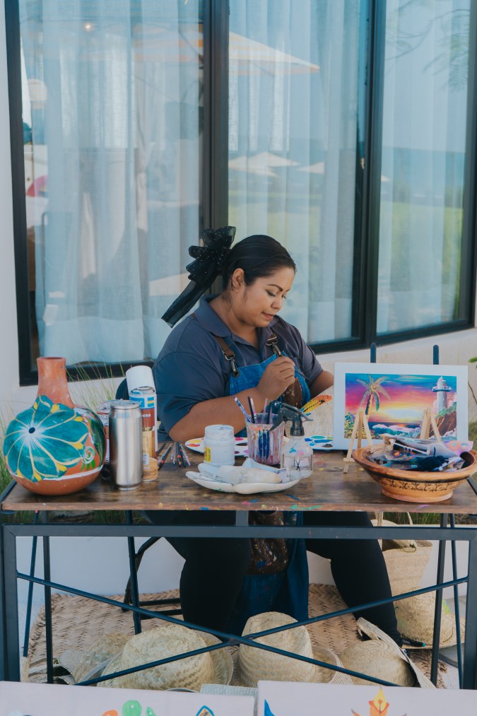 Artesana de Nayarit pintando cerámica en un taller dentro de UNICO 20°105°, parte del programa cultural del hotel.