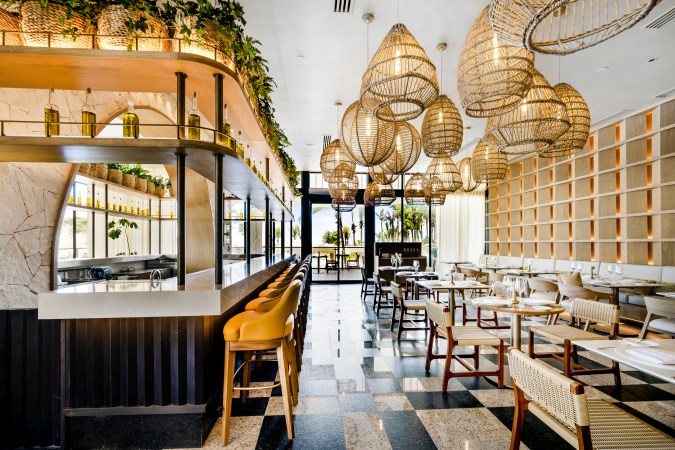 Interior de LIA, el restaurante italiano de UNICO 20°105°, con iluminación natural, lámparas de mimbre y diseño contemporáneo en tonos claros.