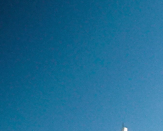 Fachada de UNICO 20°105° vista desde la piscina principal, con palmeras y camastros en el área exterior.