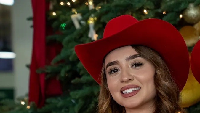 Las Marías, dúo de música mexicana, vestidas de rojo durante la activación navideña “Caroling All the Way con Coca-Cola” en Los Ángeles.
