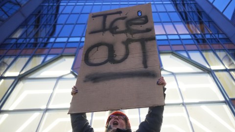Un manifestante sostiene un cartel que dice "ICE OUT" durante una protesta en Minneapolis.