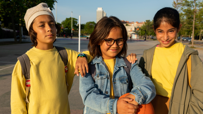 Tres niñas posan sonrientes al aire libre en imagen del informe de tendencias de paternidad de Pinterest 2026