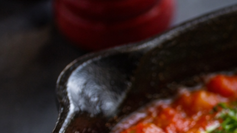 Cena casera alta en proteína con huevos en salsa de tomate y pan tostado.