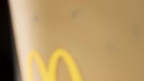 Primer plano de un sándwich Egg McMuffin de McDonald's con huevo circular, tocineta canadiense y queso derretido en un muffin inglés tostado.