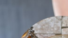 Una taza de infusiones calientes sobre una mesa de noche de madera, con ingredientes naturales como jengibre, limón y canela, en un ambiente nocturno relajado y acogedor.