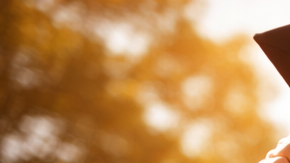Joven atleta latino celebrando graduación universitaria en campus de Estados Unidos con uniforme deportivo y diploma