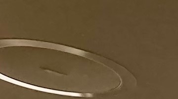 Primer plano de la hamburguesa Big Arch de McDonald's con dos carnes, queso cheddar blanco derretido, cebollas crujientes y pan con semillas de sésamo y amapola.