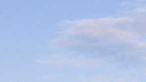 Vista aérea de varias islas boscosas en el lago Vänern, con una tienda de campaña roja instalada junto al agua.