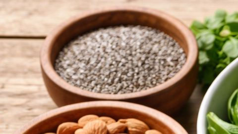 Alimentos ricos en magnesio como espinaca, frutos secos, semillas, legumbres y pescado sobre una mesa