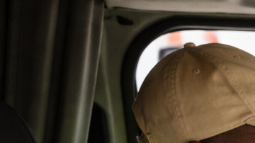 Persona conduciendo un camión con instructor durante entrenamiento para licencia CDL en Estados Unidos