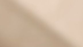 Primer plano de un vaso de Chai Latte de Starbucks con leche vaporizada y espuma, mostrando la textura cremosa de la bebida de té negro y especias sobre una mesa de madera