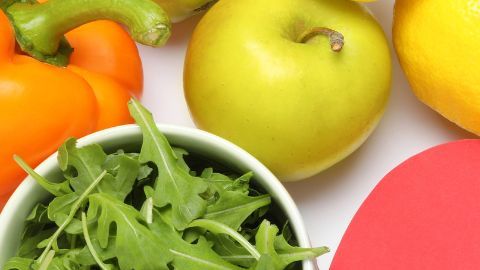 Imagen de dos figuras ilustrativas de los riñones rodeada de alimentos saludables,