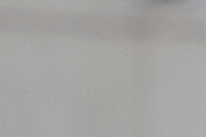 Two men in formal attire stand outdoors, one is wearing glasses and a suit with a tie, and the other is in a gray suit with a tie. They appear to be engaged in a serious discussion.