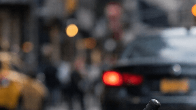 Scooter eléctrico en calle urbana de Estados Unidos con tráfico al fondo y sensación de accidente