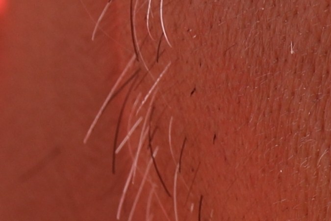 Hombre comiendo un muslo de pollo frito.