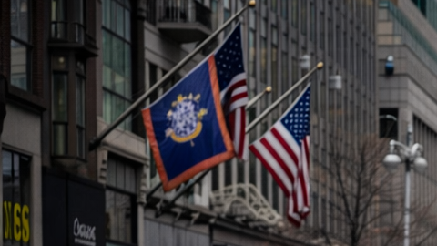 Miles de corredores participan en la media maratón de Nueva York corriendo por una avenida de Manhattan rodeados de edificios y espectadores