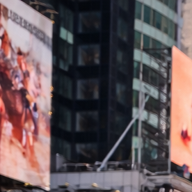 Multitud de turistas caminando por Times Square en Manhattan rodeados de pantallas gigantes y rascacielos