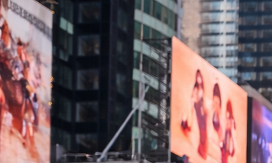 Multitud de turistas caminando por Times Square en Manhattan rodeados de pantallas gigantes y rascacielos
