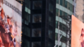 Multitud de turistas caminando por Times Square en Manhattan rodeados de pantallas gigantes y rascacielos