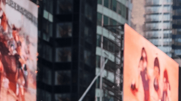 Multitud de turistas caminando por Times Square en Manhattan rodeados de pantallas gigantes y rascacielos