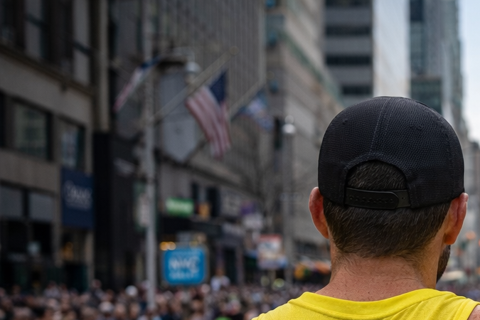 Corredor participando en una media maratón mientras avanza por una avenida urbana durante una carrera de 21 kilómetros