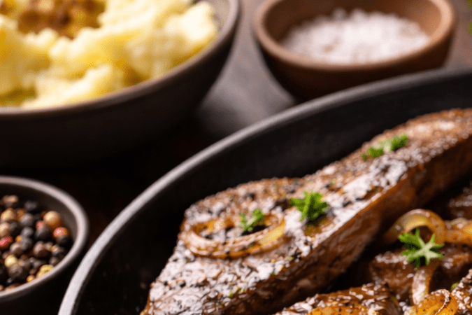 Hígado de res cocinado en sartén con cebolla caramelizada y perejil fresco
