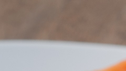 Un pato blanco con papayas con sus semillas cortadas, sobre un fondo de madera.