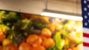 Persona usando una caja de autopago en un supermercado con varias máquinas de self-checkout