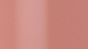 Vaso con jugo de remolacha sobre fondo blanco con remolachas y zanahorias a un lado.